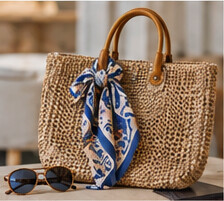 Illustrative woven bag with a patterned scarf and sunglasses